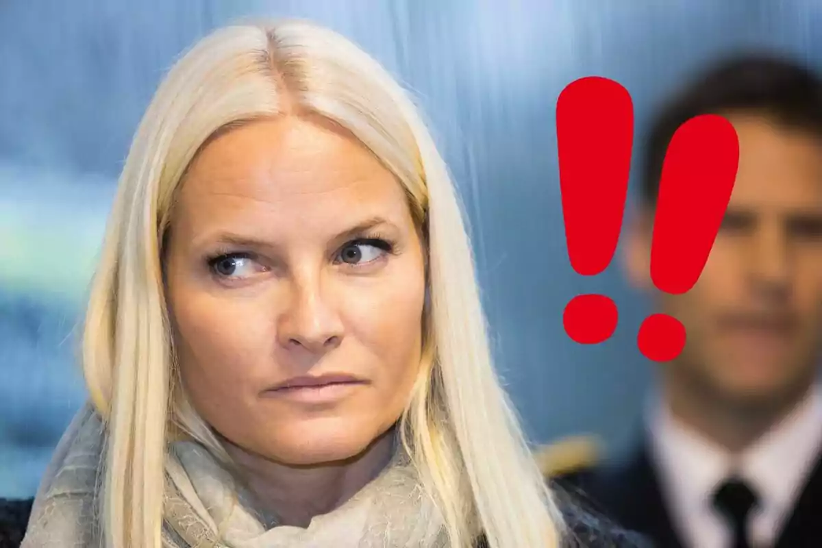 Mette-Marit looks to the side with a serious expression while a red exclamation mark appears in the background.