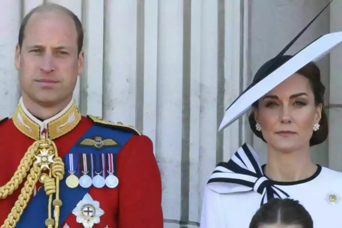 A couple dressed formally, the man wearing a red military uniform with medals and the woman wearing an elegant white dress with a matching hat, both standing in front of a background of columns. A couple dressed formally, the man wearing a red military uniform with medals and the woman wearing an elegant white dress with a matching hat, both standing in front of a background of columns.