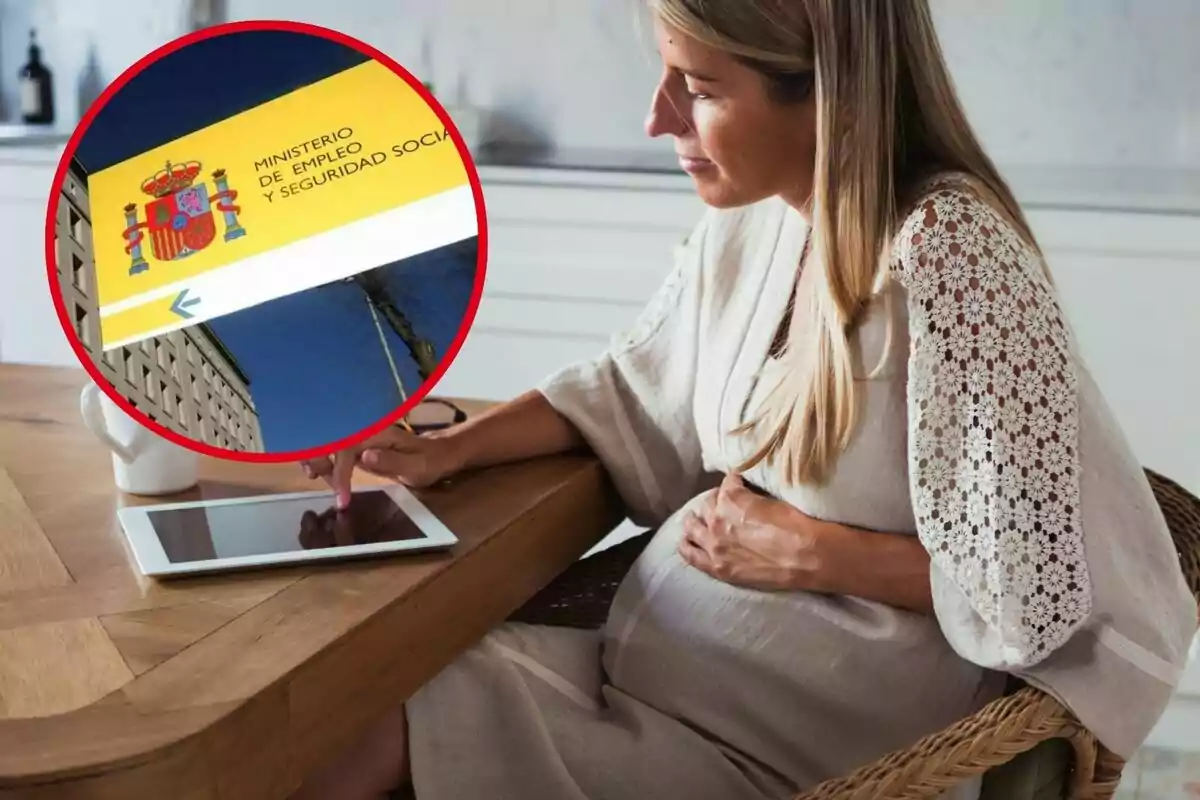 Una dona embarassada està asseguda en una taula de fusta, usant una tauleta, amb una imatge ampliada del Ministeri d'Ocupació i Seguretat Social d'Espanya a la cantonada superior esquerra. Una dona embarassada està asseguda en una taula de fusta, usant una tauleta, amb una imatge ampliada del Ministeri d'Ocupació i Seguretat Social d'Espanya a la cantonada superior esquerra.