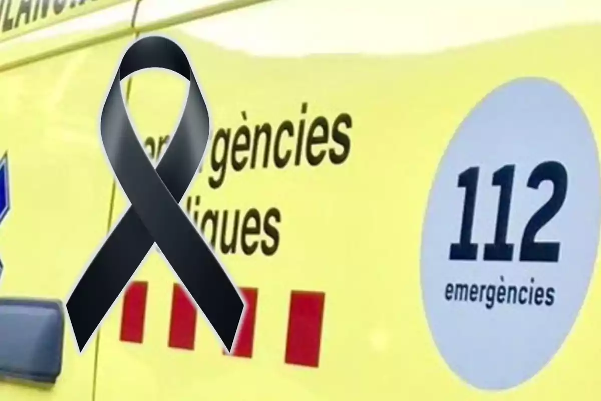 Una cinta negra sobre una ambulància groga amb el número d?emergències 112.