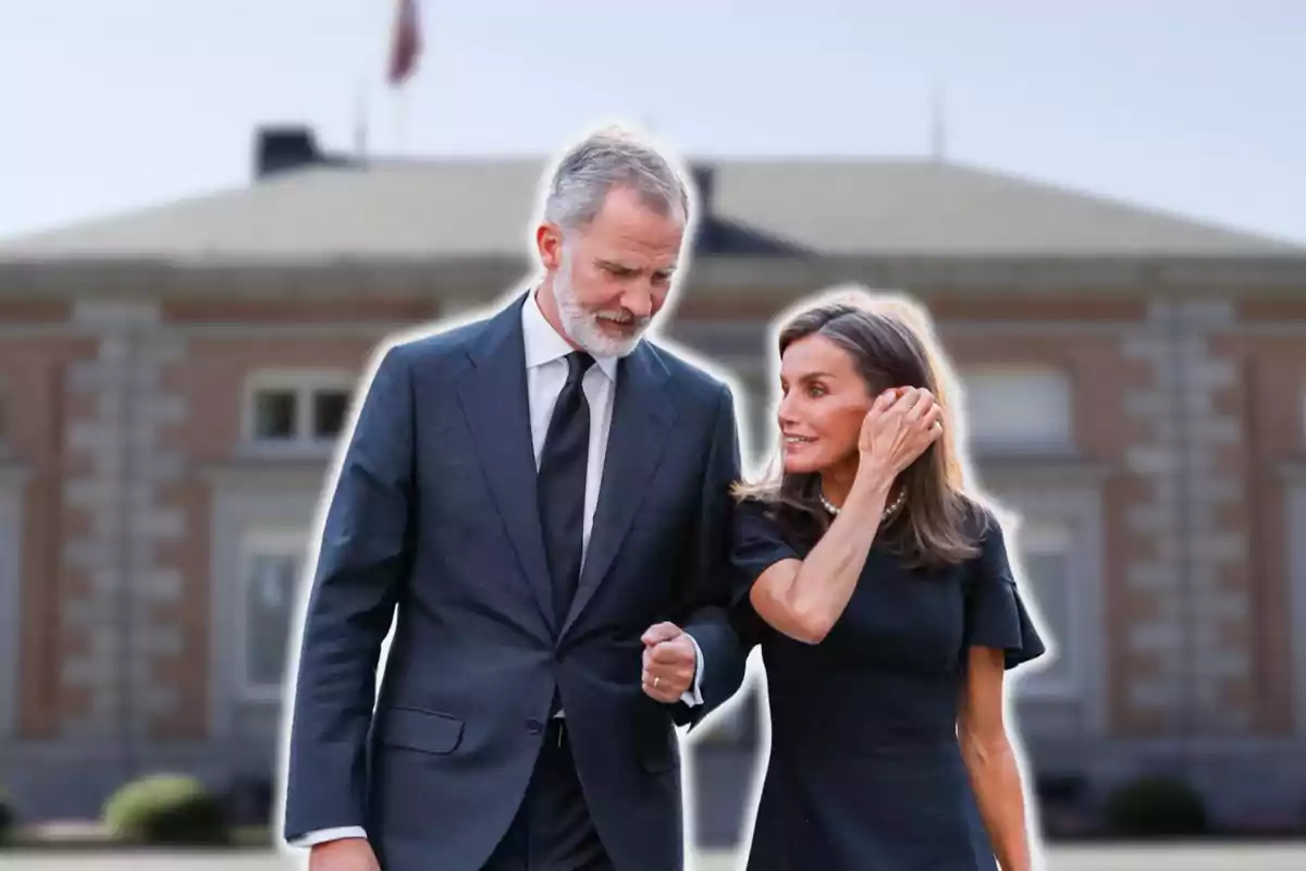 Una pareja caminando frente a un edificio elegante.