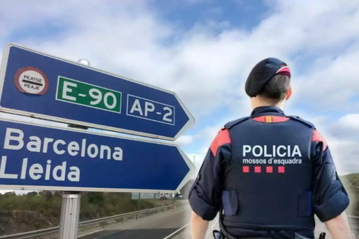 Un agent dels Mossos d'Esquadra d'esquena davant d'un senyal de trànsit que indica les direccions cap a Barcelona i Lleida a l'autopista E-90 AP-2.