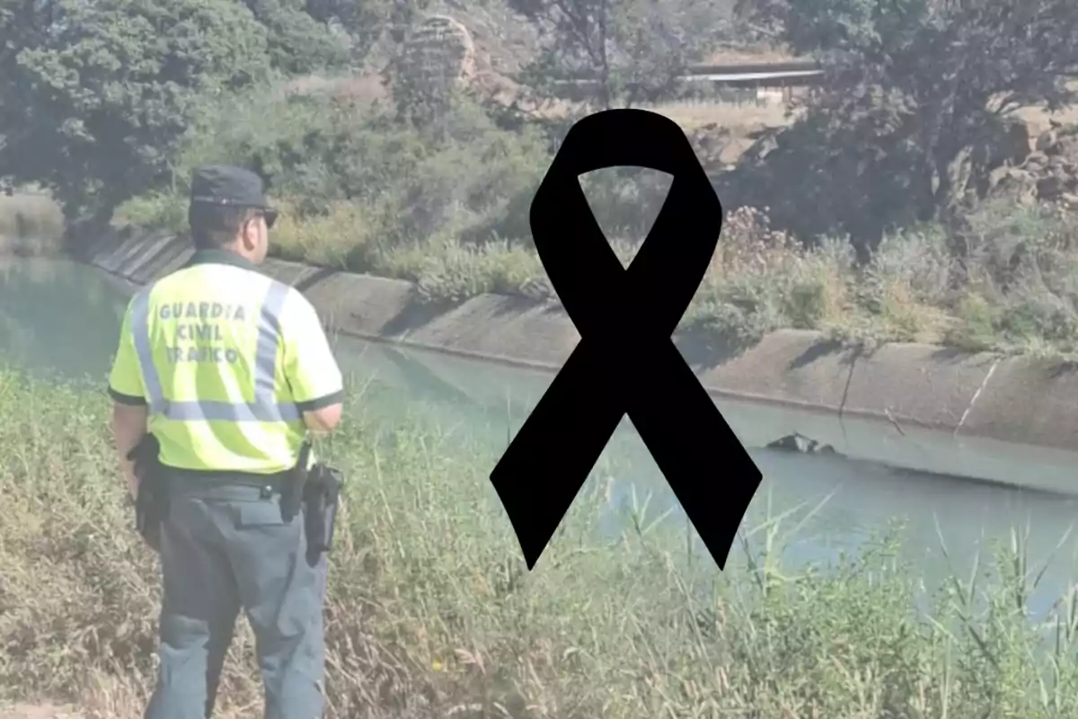 Agent de la Guàrdia Civil de Trànsit observa un canal d’aigua mentre un llaç negre de dol apareix al centre de la imatge.