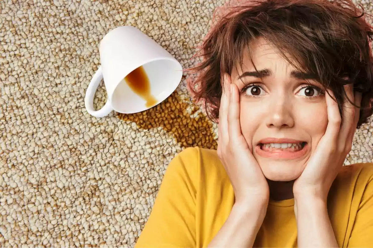 Persona con expresión de preocupación junto a una taza de café volcada sobre una alfombra.