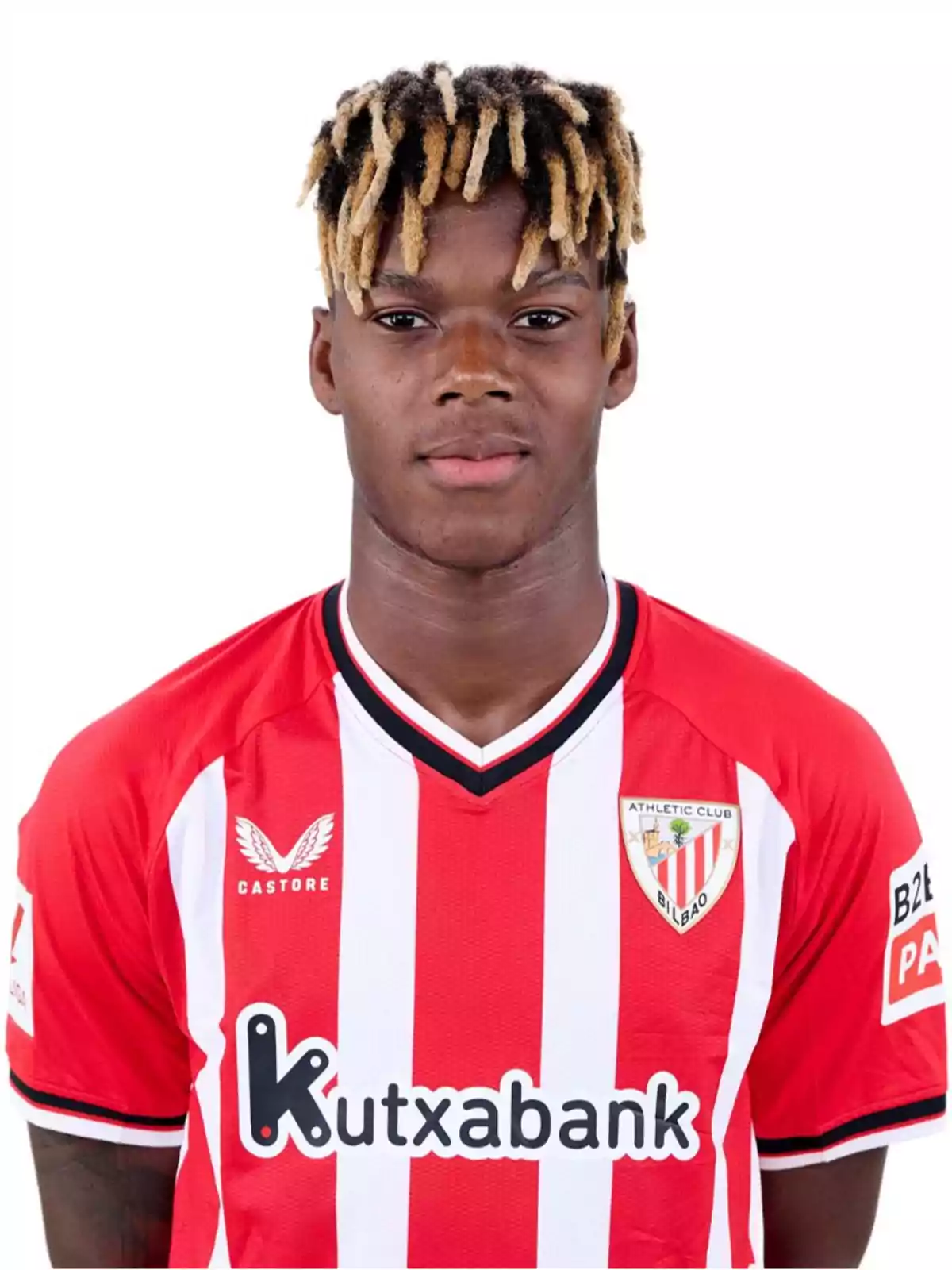 Un jugador de fútbol con una camiseta roja y blanca del Athletic Club de Bilbao, con el logo de Kutxabank en el pecho y el logo de Castore en el hombro.