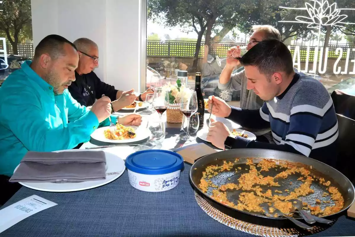 Un grup de 4 homes menjant un arròs en un restaurant