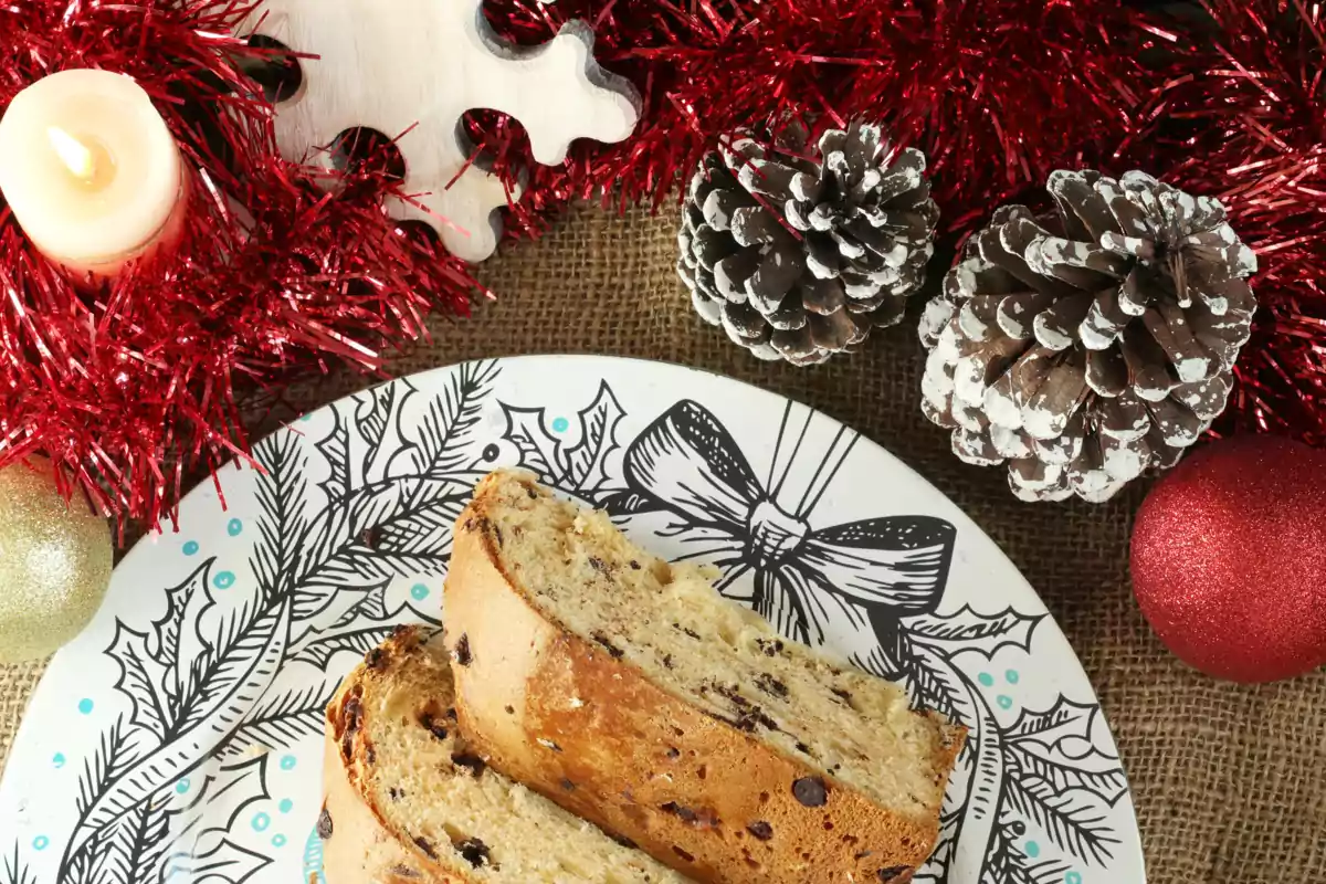 Panettone en un plato y decoración navideña