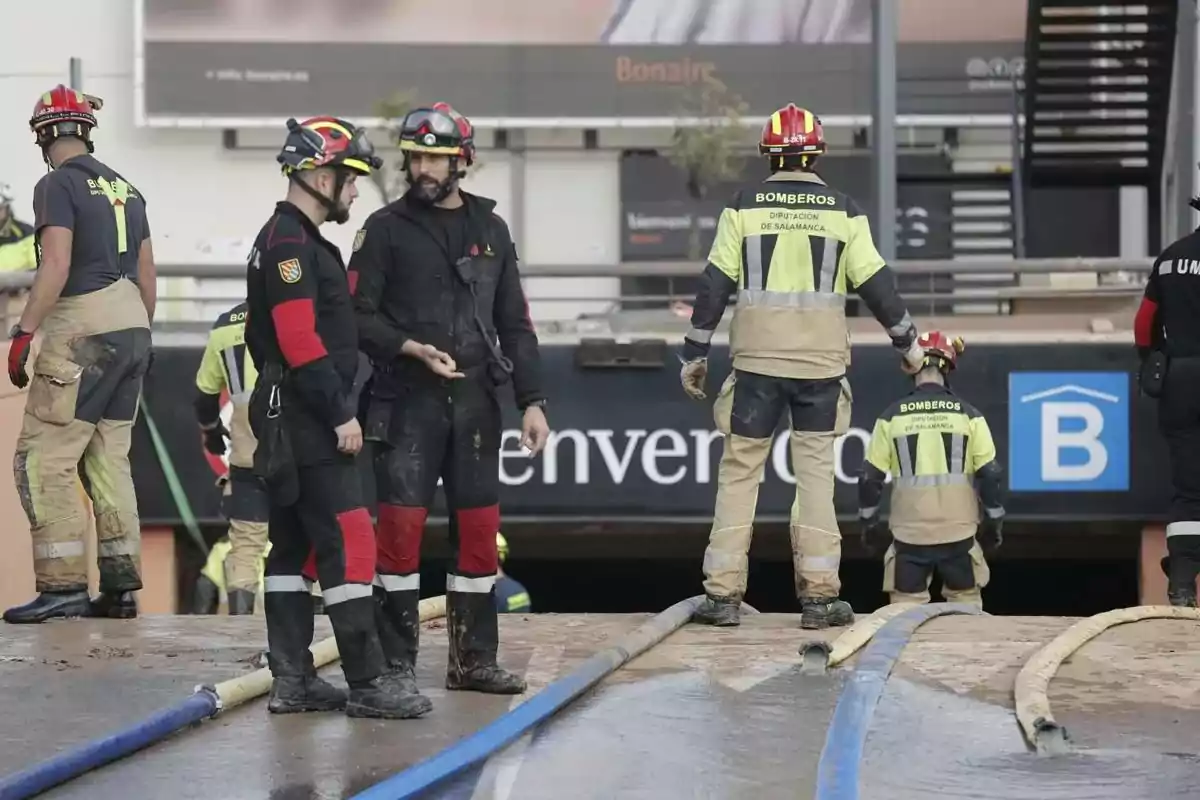 Bomberos y la UME trabajando en una operación de rescate con mangueras en el parking del Bonaire