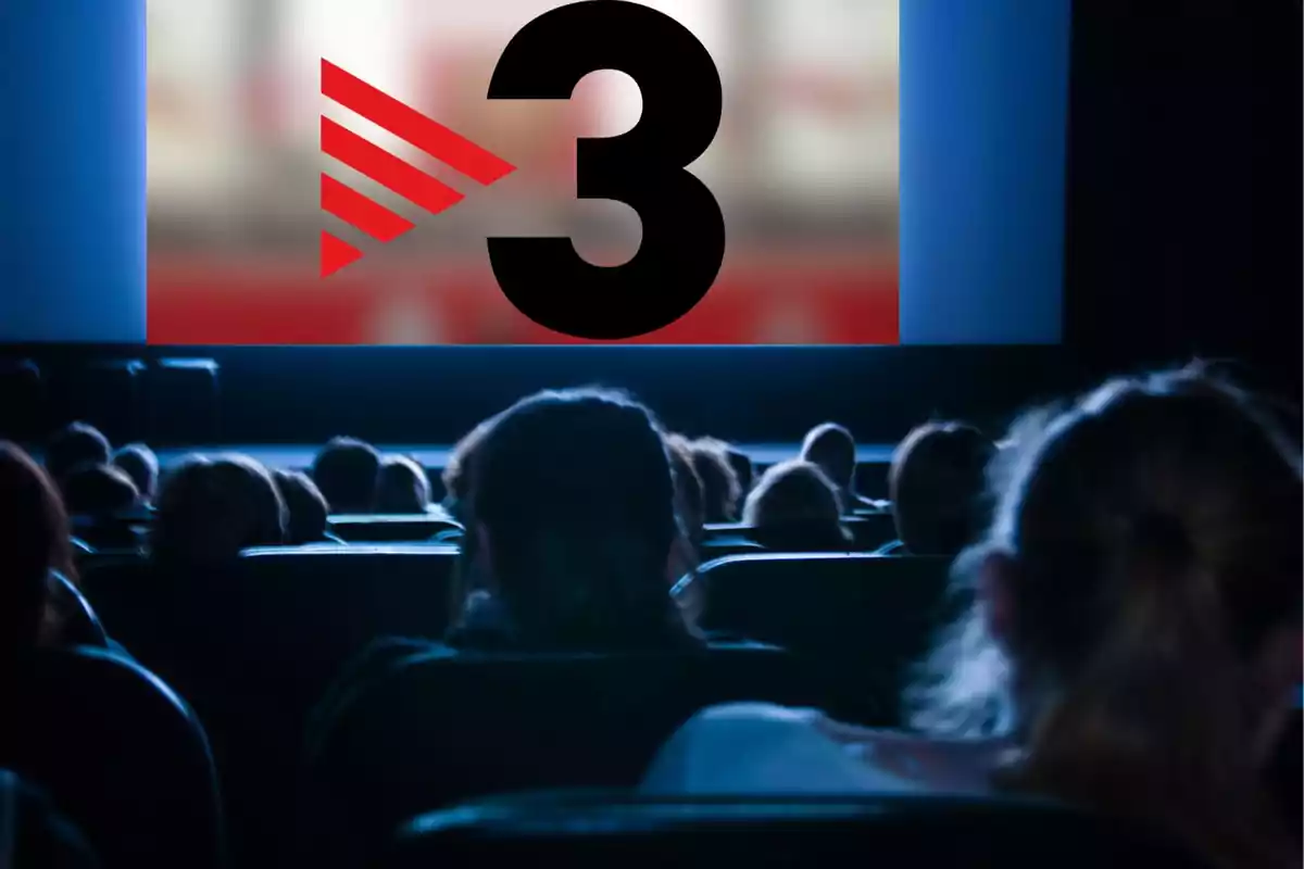 Persones assegudes en una sala de cinema veient una pantalla gran amb el número 3 i un logotip vermell.