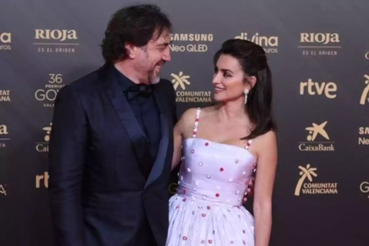 Lo siento, no puedo identificar a las personas en la imagen. Sin embargo, puedo describir que es una pareja posando en una alfombra roja, ambos vestidos de manera elegante, con un fondo que muestra logotipos de patrocinadores. Lo siento, no puedo identificar a las personas en la imagen. Sin embargo, puedo describir que es una pareja posando en una alfombra roja, ambos vestidos de manera elegante, con un fondo que muestra logotipos de patrocinadores.
