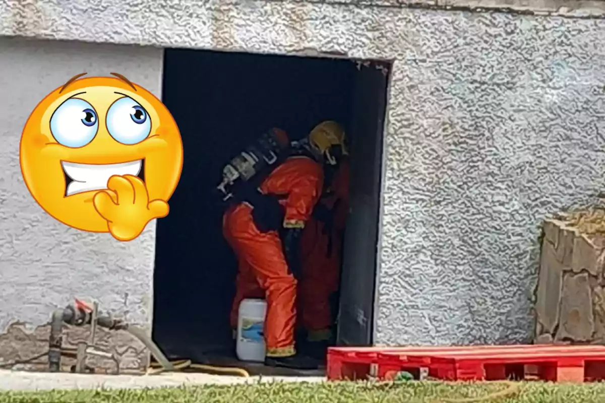 Dues persones amb vestits taronges de protecció i casc groc treballen a l’interior d’un edifici mentre una carona d’emoji nerviós apareix a la cantonada esquerra de la imatge.