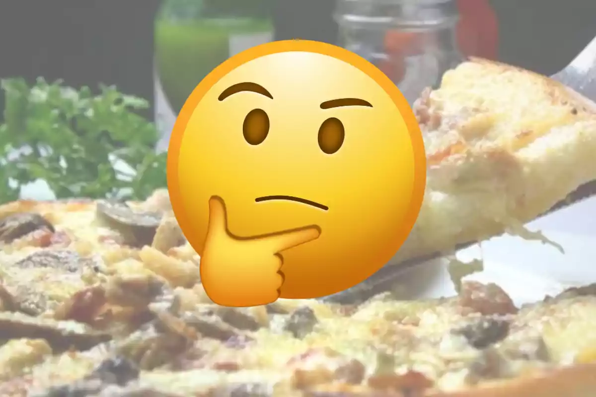 Emoji de cara pensativa sobre una pizza acabada de servir