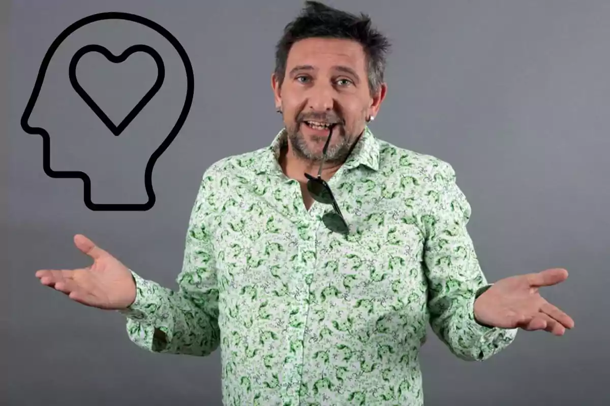 Hombre con camisa verde estampada, sosteniendo gafas de sol en la boca y con un icono de cabeza con corazón a la izquierda.