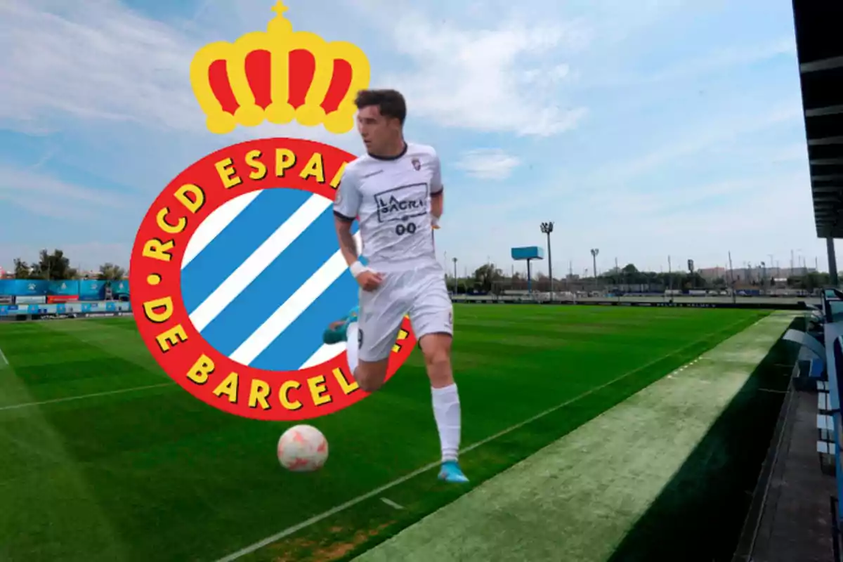 Jugador de futbol en uniforme blanc corrent en un camp de futbol amb l'escut del RCD Espanyol de Barcelona al fons.