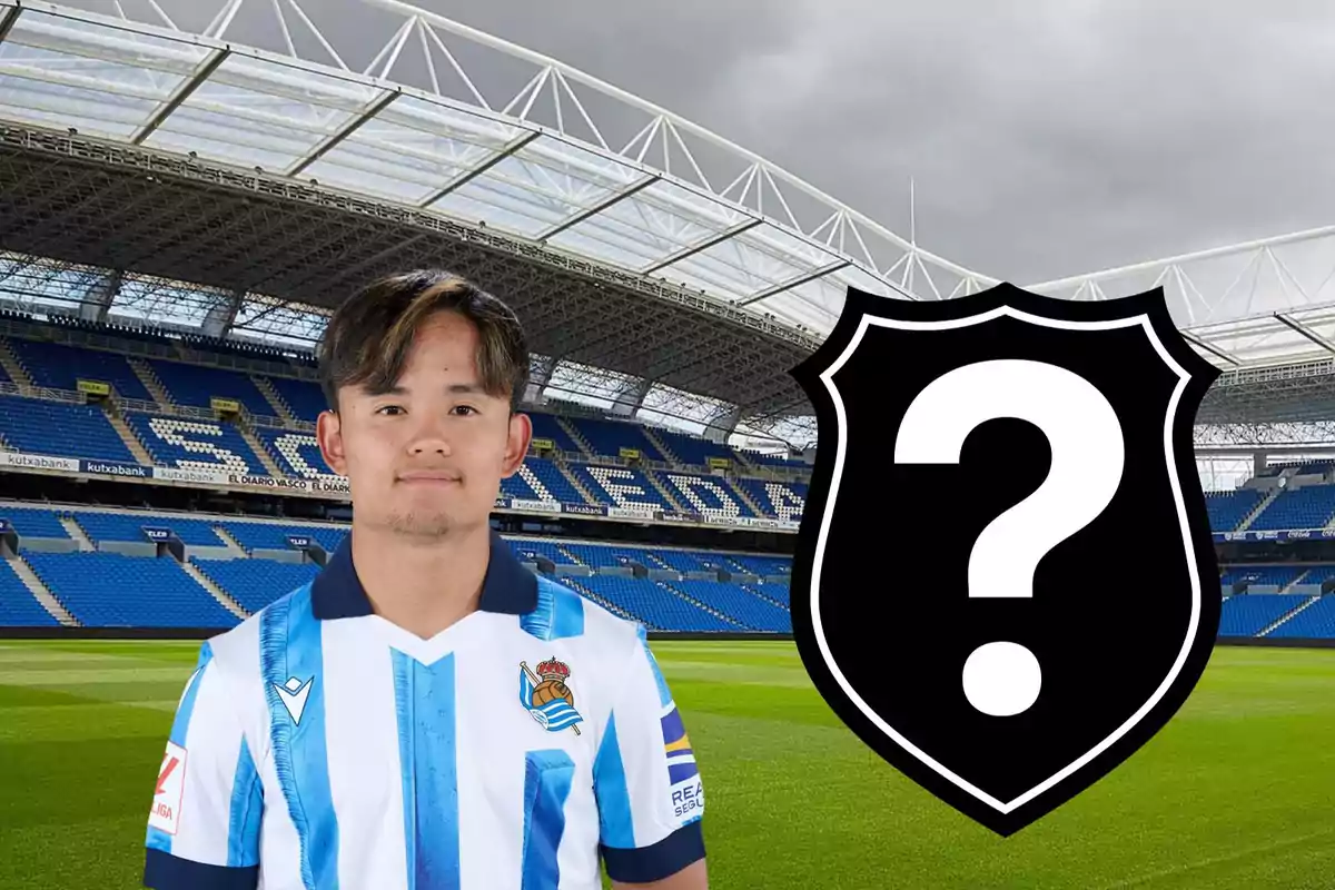 Jugador de fútbol con uniforme de la Real Sociedad en un estadio, junto a un escudo negro con un signo de interrogación.