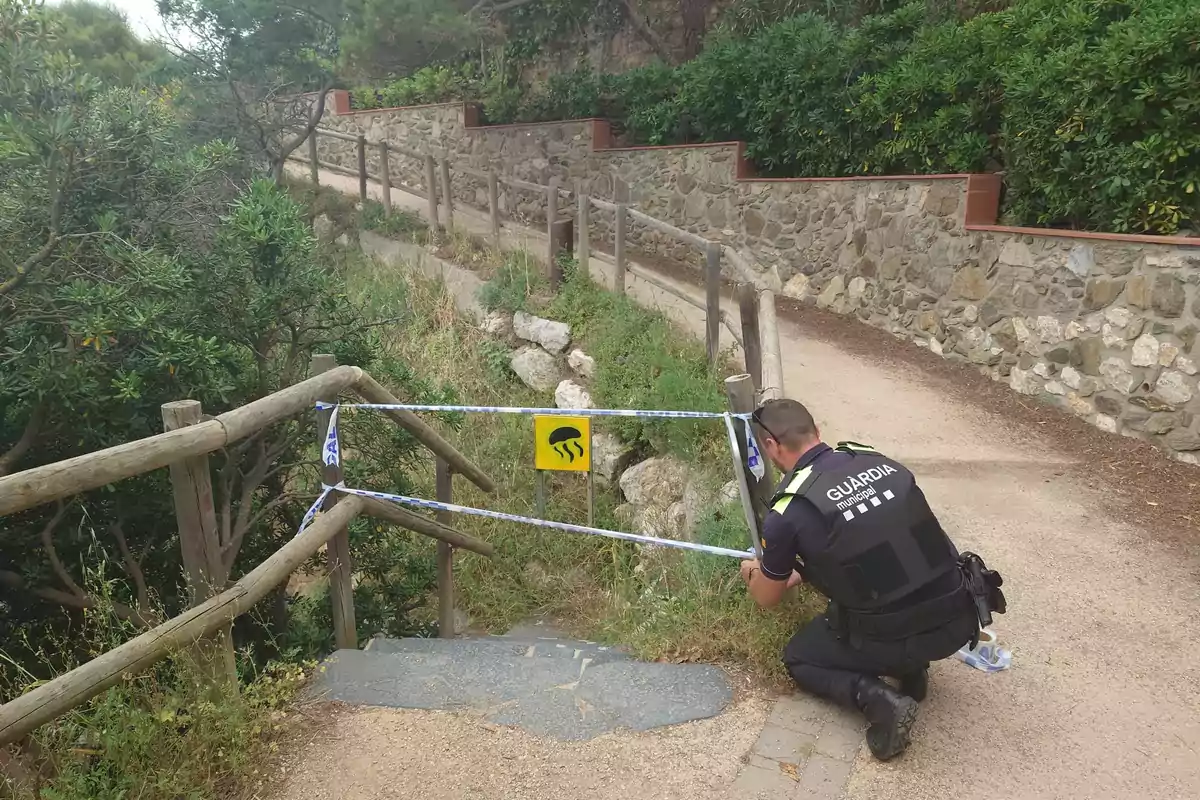 Un guardia municipal cierra el acceso a una playa