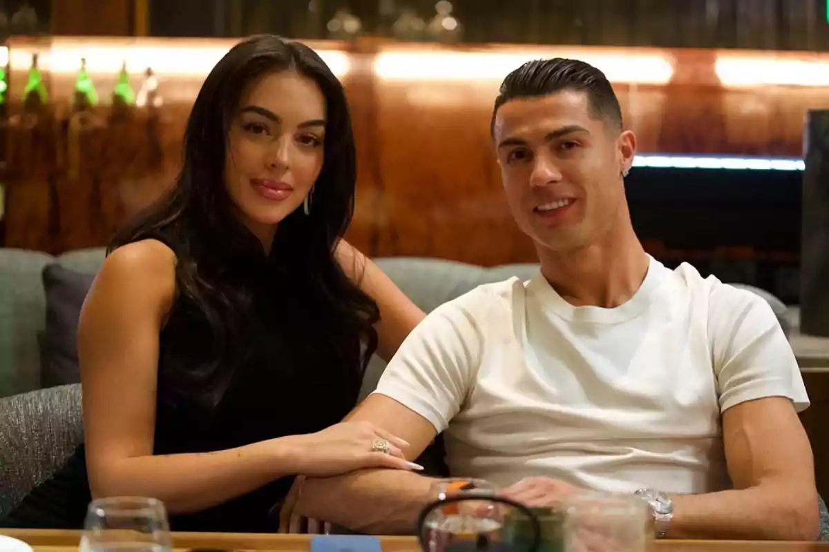 Georgina Rodríguez i Cristiano Ronaldo asseguts en un ambient acollidor, tots dos somriuen mentre posen per a la càmera. Georgina Rodríguez i Cristiano Ronaldo asseguts en un ambient acollidor, tots dos somriuen mentre posen per a la càmera.