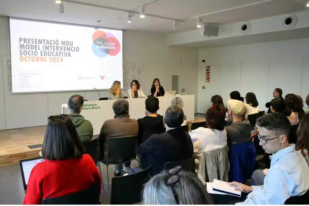 Persones assistint a una presentació sobre un nou model d'intervenció socioeducativa a la Biblioteca Pilarin Bayés.