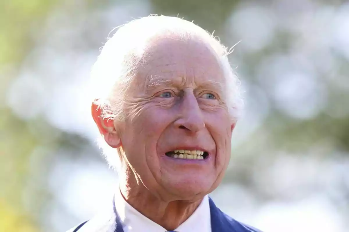 Charles III with white hair and intense facial expression in an outdoor setting with out-of-focus background. Charles III with white hair and intense facial expression in an outdoor setting with out-of-focus background.