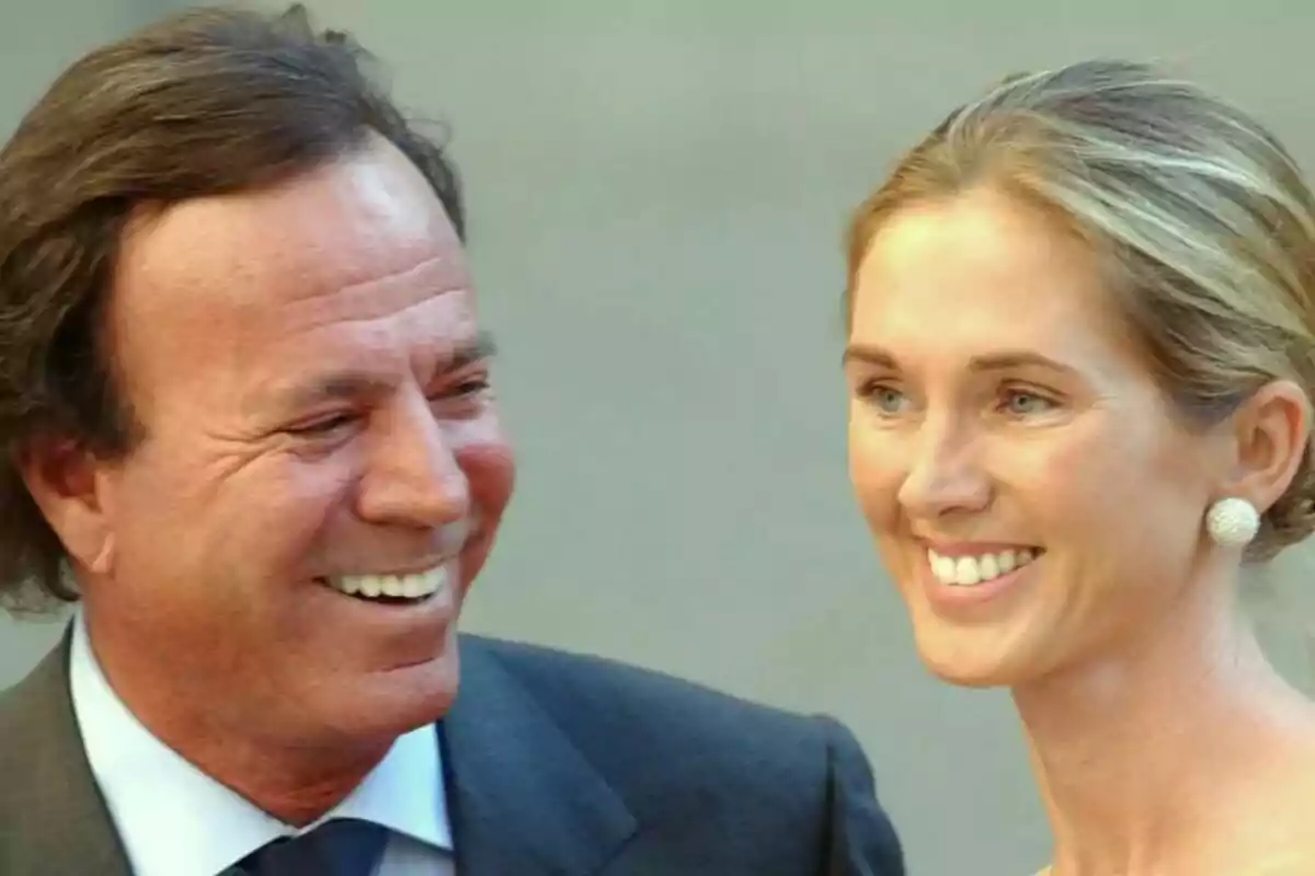 Julio Iglesias i Miranda Rijnburger somrient, Julio amb vestit i corbata i Miranda amb aretes grans i el cabell recollit. Julio Iglesias i Miranda Rijnburger somrient, Julio amb vestit i corbata i Miranda amb aretes grans i el cabell recollit.