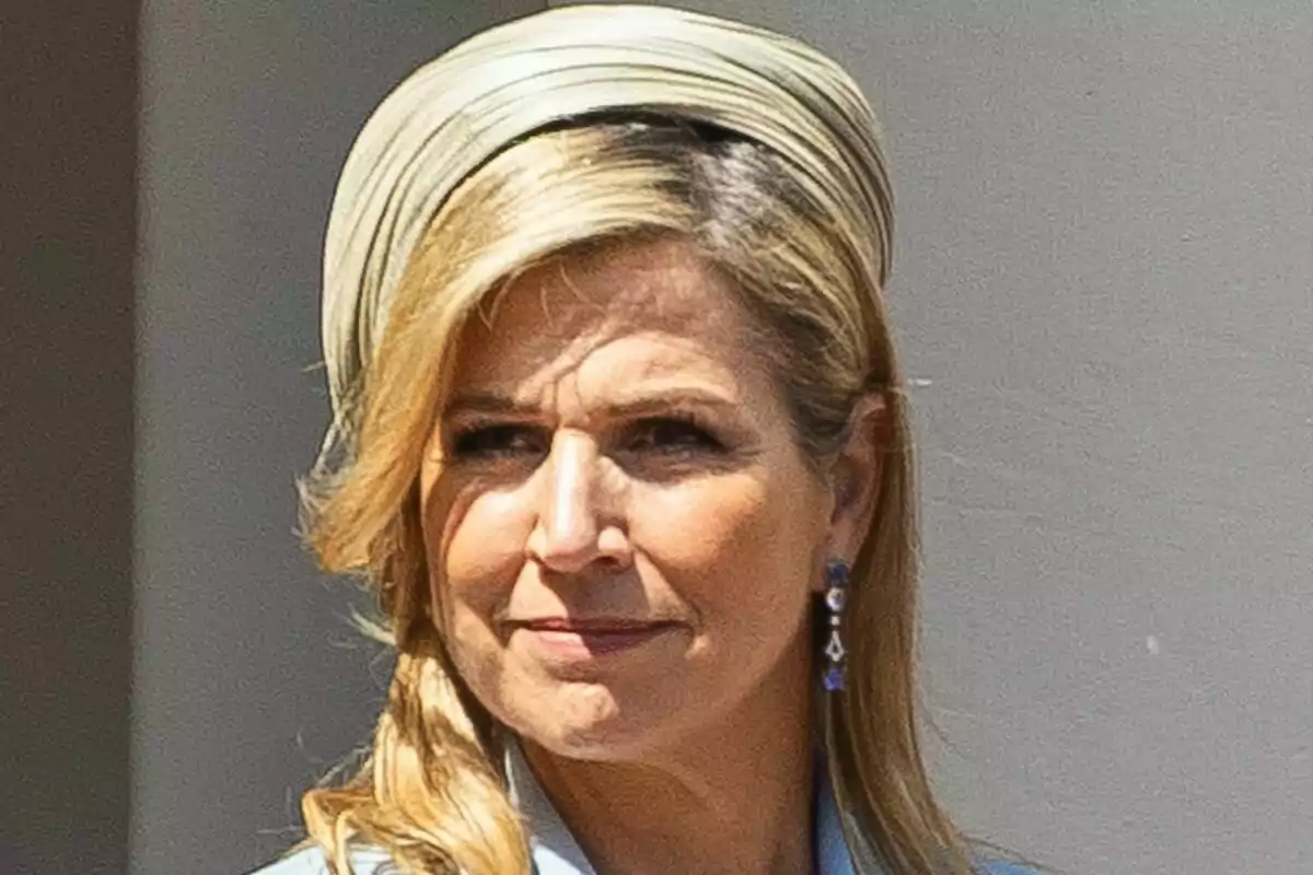 Máxima of the Netherlands with a light headpiece slightly smiles while looking to the side.