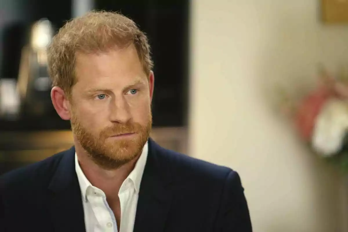 Príncep Harry vestit amb un vestit fosc i camisa blanca, assegut en un entorn interior. Príncep Harry vestit amb un vestit fosc i camisa blanca, assegut en un entorn interior.