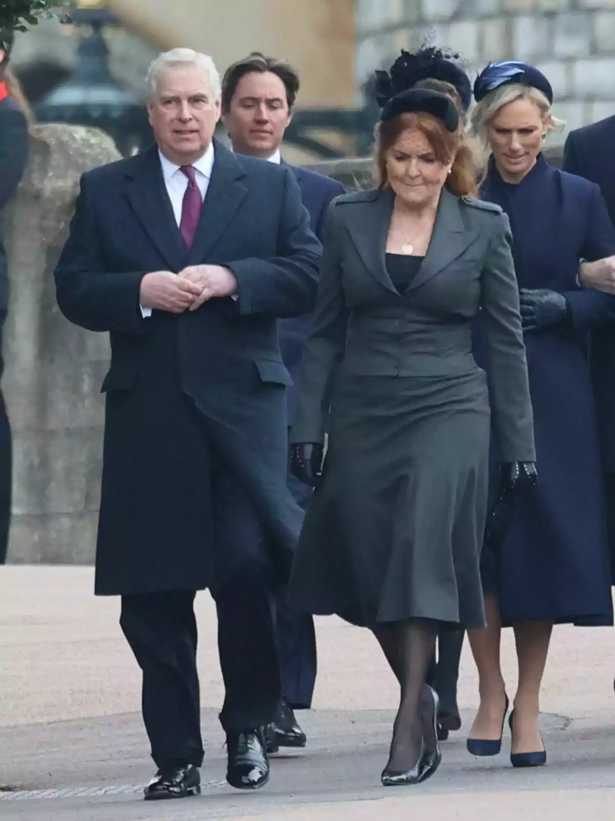 A group of formally dressed people walk down a street, with grey-haired Prince Andrew and red-haired Sarah Ferguson at the front. A group of formally dressed people walk down a street, with grey-haired Prince Andrew and red-haired Sarah Ferguson at the front.
