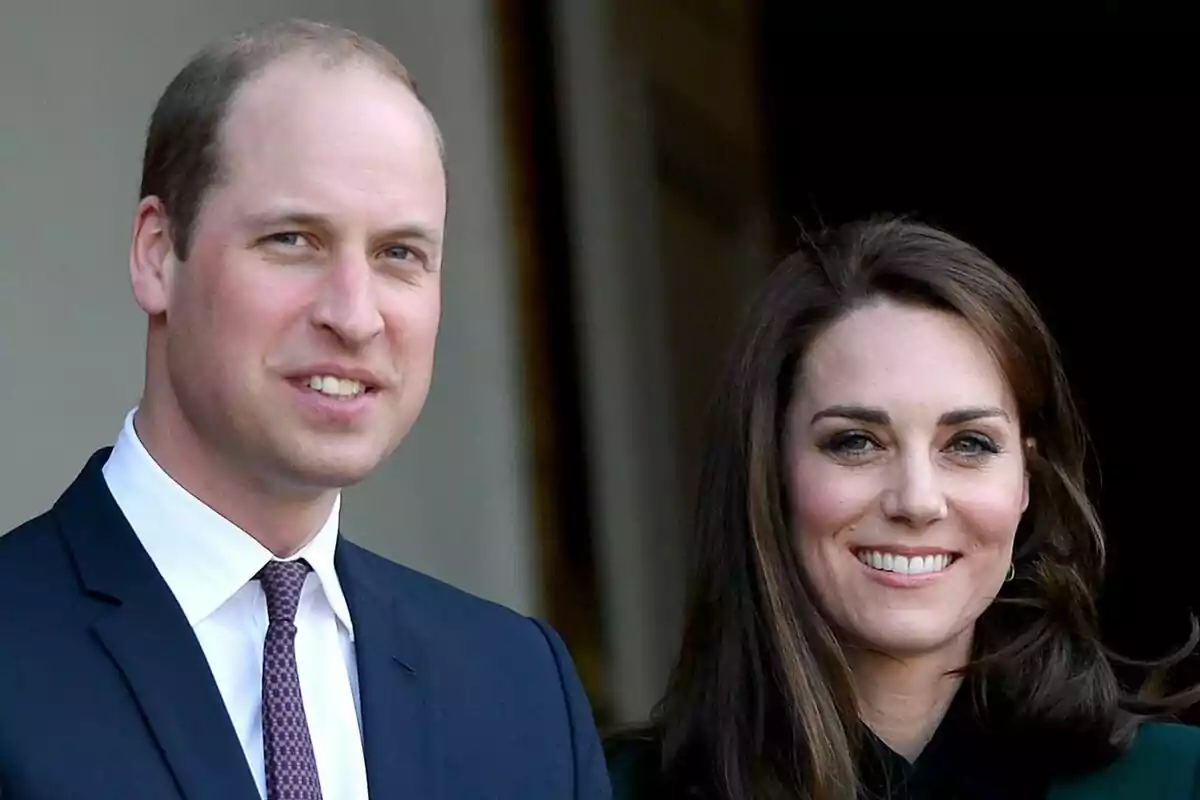 Prince William and Kate Middleton smiling while posing together at a formal event. Prince William and Kate Middleton smiling while posing together at a formal event.