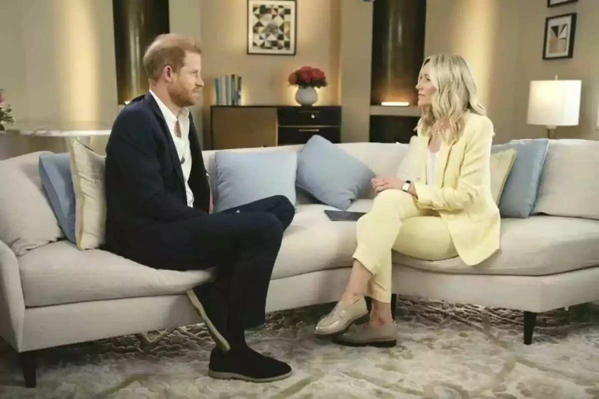Príncep Harry i periodista asseguts en un sofà, Harry amb vestit fosc i l'altra amb vestit clar, conversant en un ambient elegant i ben il·luminat. Príncep Harry i periodista asseguts en un sofà, Harry amb vestit fosc i l'altra amb vestit clar, conversant en un ambient elegant i ben il·luminat.