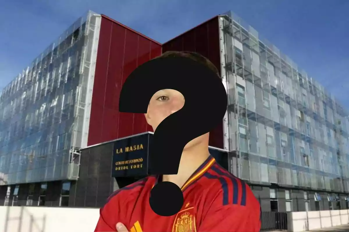 Una persona con una camiseta roja de la selección española de fútbol está frente a un edificio moderno con un letrero que dice "La Masia Centre de Formació Oriol Tort" y su rostro está cubierto por un signo de interrogación.