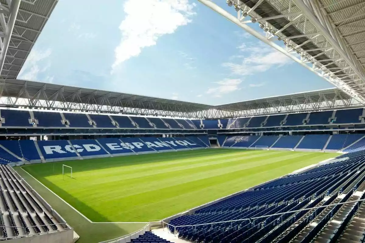 Estadio de fútbol vacío con asientos azules y el nombre "RCD Espanyol" en las gradas.