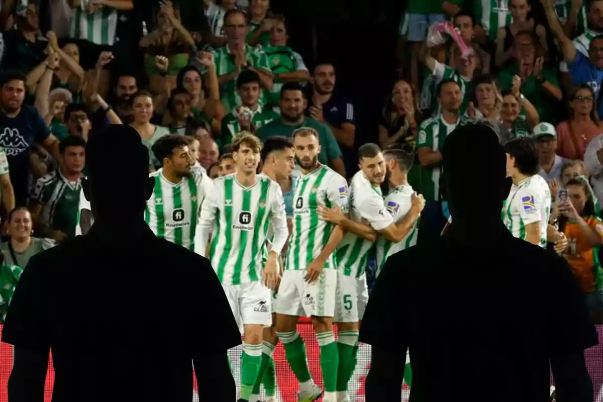Muntatge amb l'equip del Real Betis celebrant un gol i dues figures negres, una a l'esquerra i l'altra a la dreta
