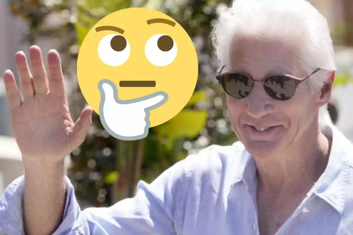 Un home de cabell blanc i ulleres de sol somriu i saluda amb la mà aixecada, mentre un emoji pensatiu cobreix part de la seva cara.