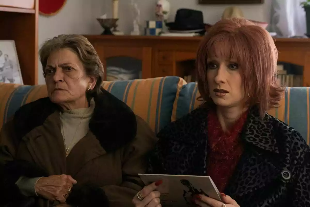 Ingrid Garcia-Jonsson como Yurena y Rocío Ibáñez como Margarita Seisdedos sentadas en un sofá con expresiones serias y preocupadas, una de ellas sostiene una hoja de papel en la serie Superestar Ingrid Garcia-Jonsson como Yurena y Rocío Ibáñez como Margarita Seisdedos sentadas en un sofá con expresiones serias y preocupadas, una de ellas sostiene una hoja de papel en la serie Superestar