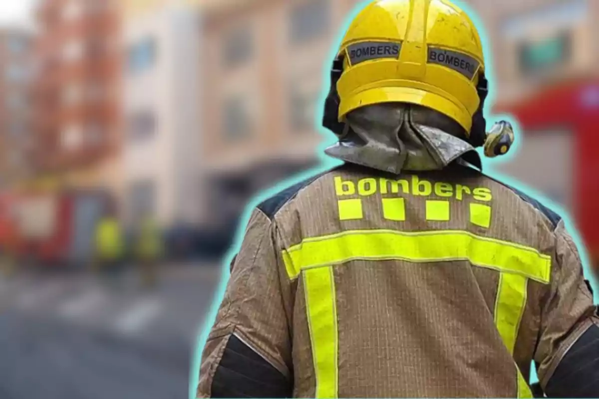 Bomber d'esquena amb uniforme i casc groc en una escena urbana desenfocada.