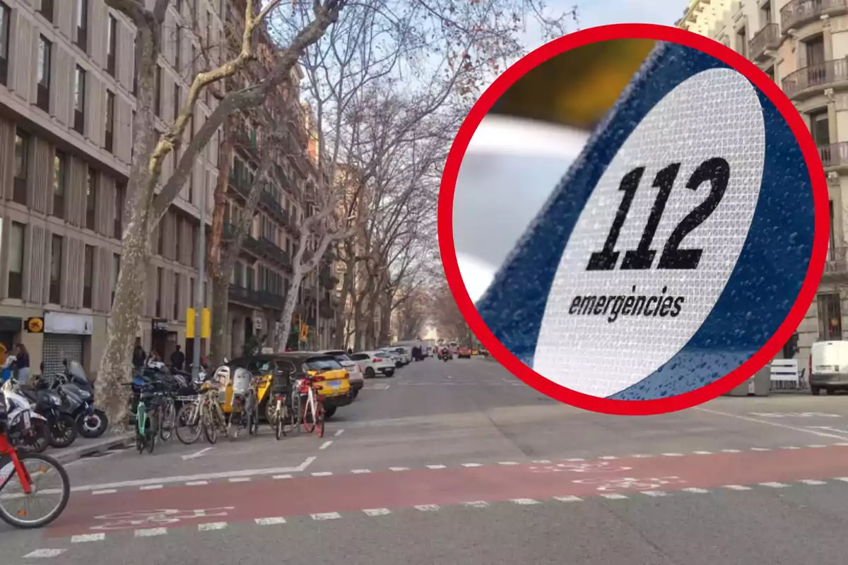 Un carrer urbà amb edificis i arbres sense fulles, bicicletes estacionades i alguns cotxes, amb un cercle vermell que conté el número 112 i la paraula "emergències".