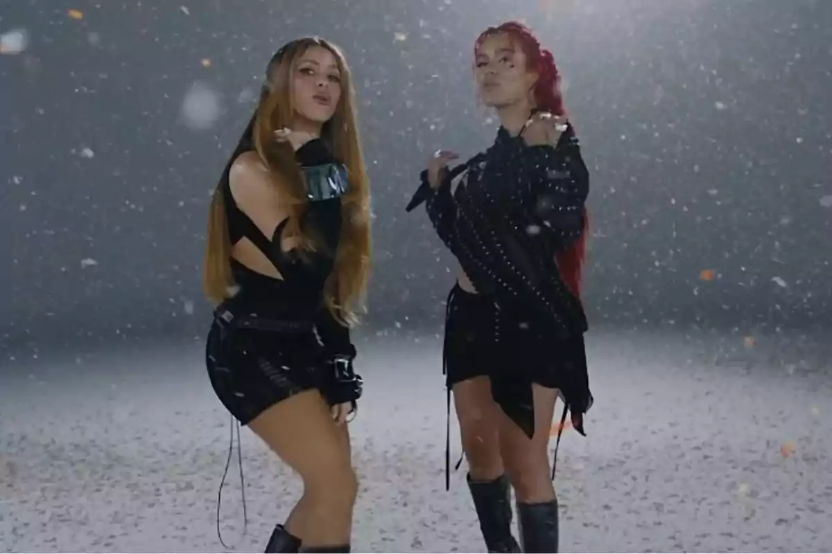 Dues dones posant en un escenari amb neu artificial, totes dues vestides de negre.