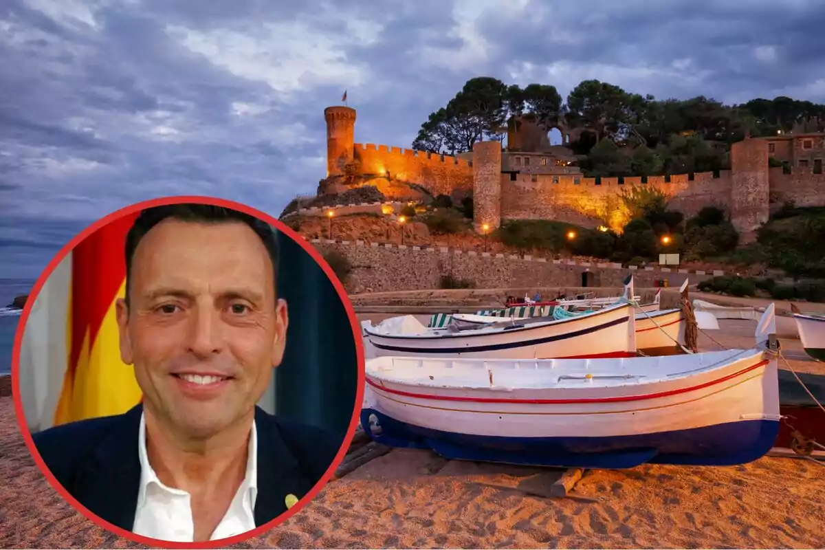 Un hombre sonriente en un círculo rojo superpuesto sobre una imagen de un castillo iluminado y barcos en la playa al atardecer.