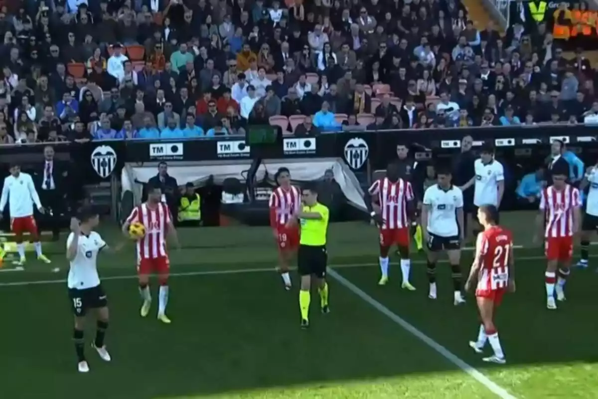 Jugadors de la UD Almeria discutint una decisió arbitral durant un partit contra el València