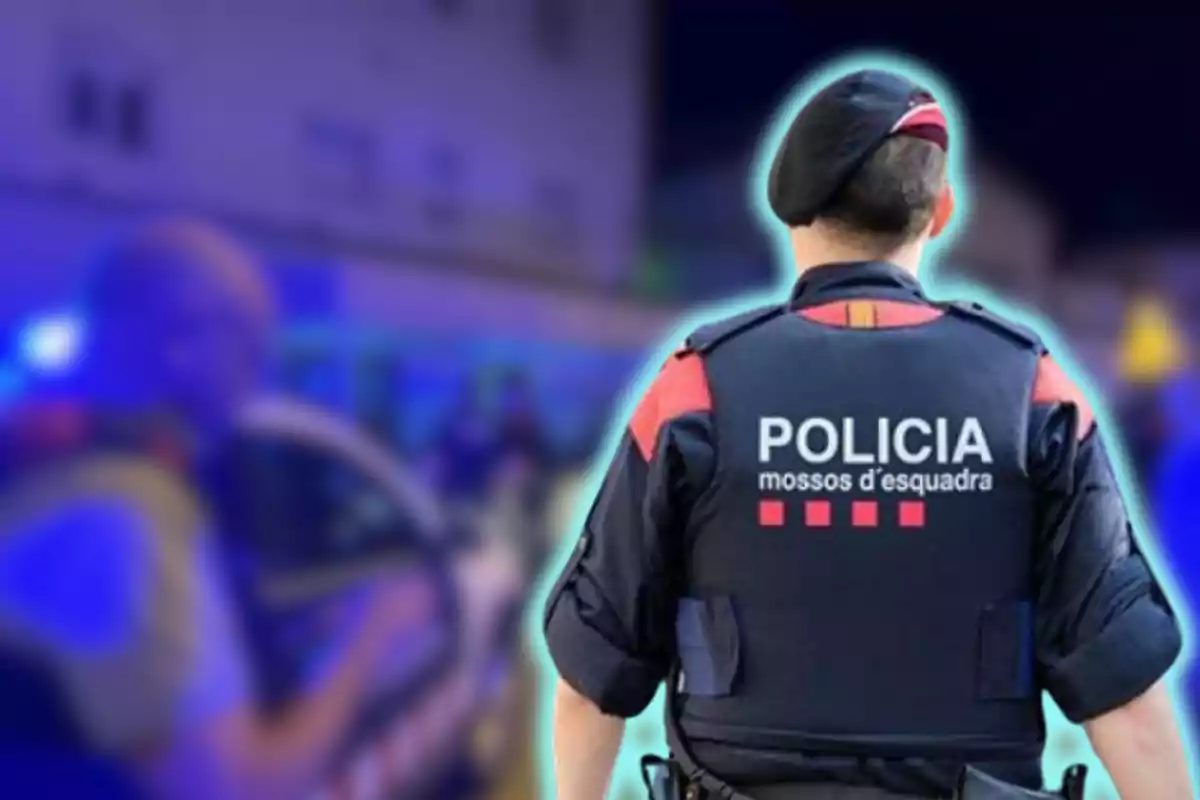 Un agent dels Mossos d'Esquadra d'esquena amb un uniforme que diu Policia en un entorn urbà desenfocat.