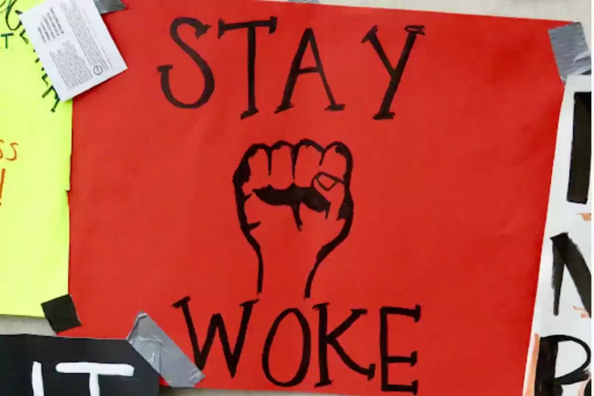 Cartell vermell amb un puny negre aixecat i les paraules "STAY WOKE".