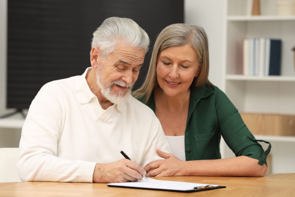 Dos personas firmando un documento